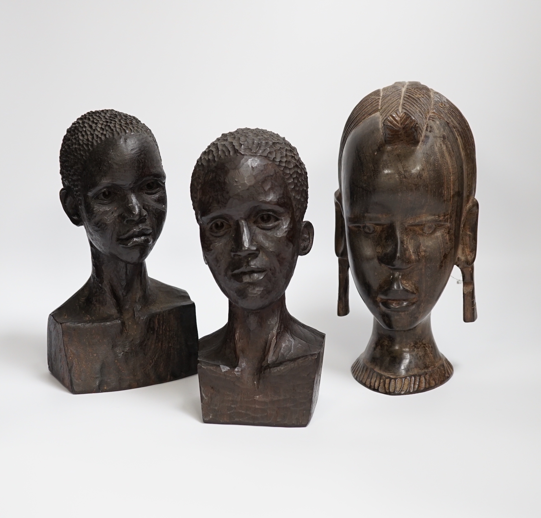 Three carved ebony African busts, tallest 23cm